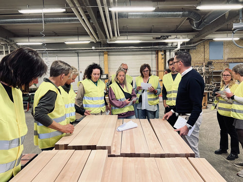 Teachers from Amsterdam in yellow vests on a tour among the timber in the Sjöbergs factory