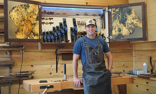 Alex Reynaud in an apron in front of the tool wall in his workshop