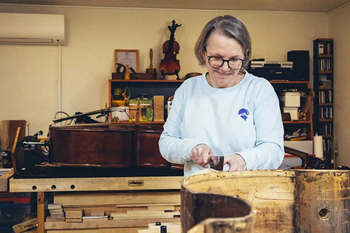 Chantal Van Lierop working on a double bass at her workbench