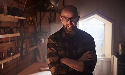 Petter Wållgren with arms crossed in a workshop